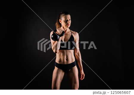 Fitness woman doing crossfit exercising with kettle bell with muscular fit and slim body. Fitness woman doing crossfit exercising with kettle bell with muscular fit and slim body. 125065607