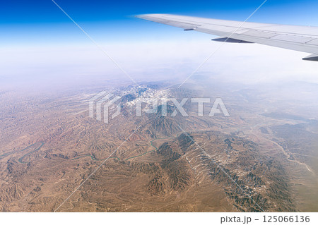 Mountain range mountains in the Tibetan Plateau in China View from above from under the wing of an airplane. Xinjiang Uygur geology Mountain range mountains in the Tibetan Plateau in China View from above from under the wing of an airplane. Xinjiang Uygur geology 125066136