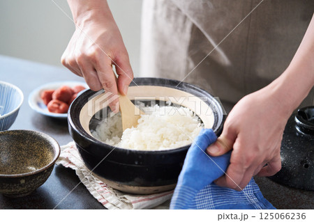 土鍋で炊いたご飯をほぐす女性 土鍋で炊いたご飯をほぐす女性 125066236