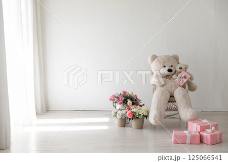 Polar bear toy and flower and gifts in the interior of a white room 125066541