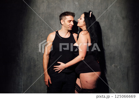 Man and woman in black lingerie in gray dark room 125066669