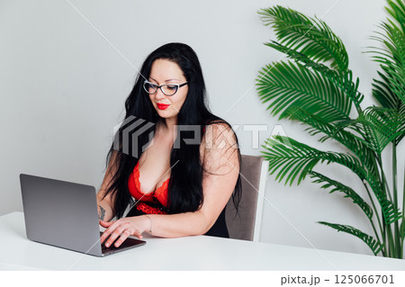 woman in lingerie working on laptop at desk online 125066701