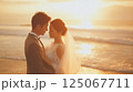 夕日につつまれた浜辺でのウェディングフォト 125067711