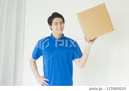 荷物を運ぶ笑顔の男性 荷物を運ぶ笑顔の男性 125068020