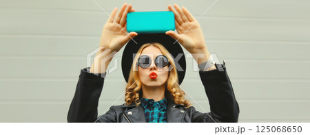 Stylish happy smiling young woman taking selfie with phone, beautiful girl using smartphone Stylish happy smiling young woman taking selfie with phone, beautiful girl using smartphone 125068650