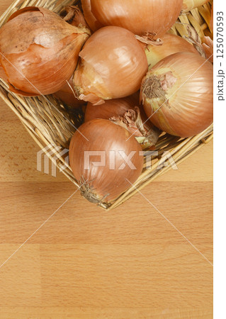Basket filled with brown onions 125070593