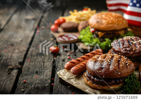 Delicious grilled hamburgers and hot dogs with a blurred american flag in the background creating a classic barbecue scene 125071889