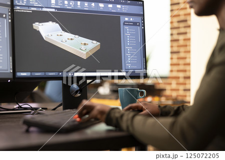 Black female developer designing industrial machinery using creative engineering software. Closeup on african american engineer seated at desk, developing digital clamps and tools on a desktop pc. Black female developer designing industrial machinery using creative engineering software. Closeup on african american engineer seated at desk, developing digital clamps and tools on a desktop pc. 125072205