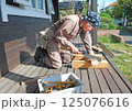 大工仕事：デッキでノコギリを使う男性 125076616