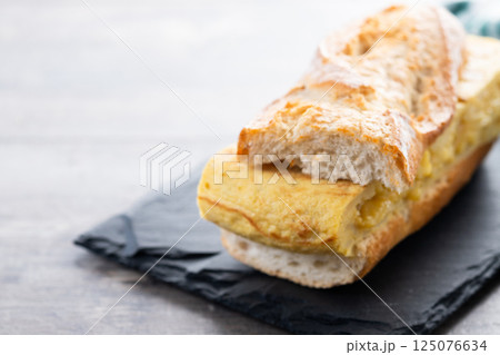 Spanish potato omelette sandwich on wooden table. Bocadillo de tortilla Spanish potato omelette sandwich on wooden table. Bocadillo de tortilla 125076634