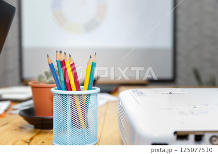 Colorful pencil in box with cactus pot on desk in office. 125077510