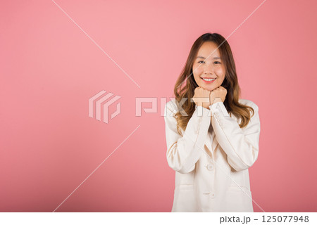 Asian happy portrait beautiful young woman standing smiling surprised excited her keeps hands pressed together under the chin studio shot on pink background with copy space for text Asian happy portrait beautiful young woman standing smiling surprised excited her keeps hands pressed together under the chin studio shot on pink background with copy space for text 125077948