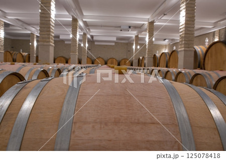 Wine barrels in the cellar of wine producer. 125078418