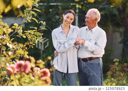Conception of love. Embracing each other. Daughter is with her senior father in the garden at daytime Conception of love. Embracing each other. Daughter is with her senior father in the garden at daytime 125078923