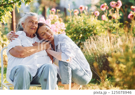 Time for a hugs. Young woman is with her senior mother is in the garden 125078946