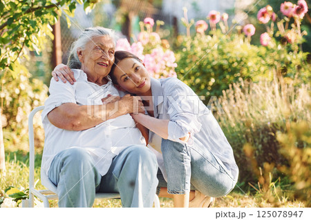 Time for a hugs. Young woman is with her senior mother is in the garden 125078947