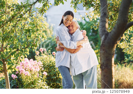 Time for a hugs. Young woman is with her senior mother is in the garden 125078949