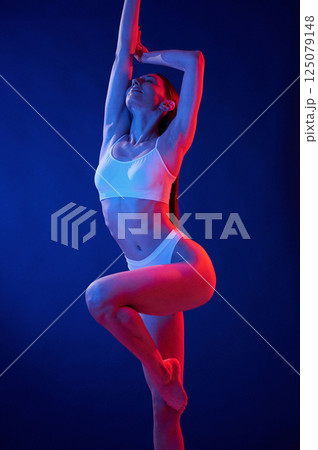 Blue and red colors. Young woman in underwear is in the studio with neon lights Blue and red colors. Young woman in underwear is in the studio with neon lights 125079148