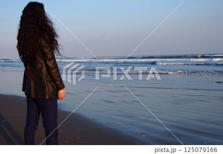 夕暮れの海辺に立つ女性 夕暮れの海辺に立つ女性 125079166