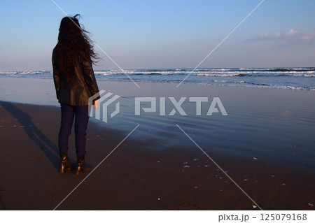 夕暮れの海辺に立つ女性 夕暮れの海辺に立つ女性 125079168