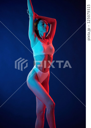 Young woman in underwear is in the studio with neon lights Young woman in underwear is in the studio with neon lights 125079315