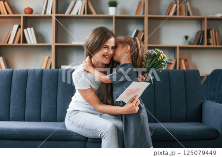 Gifts at mother's day. Young woman with her daughter is together at apartment 125079449
