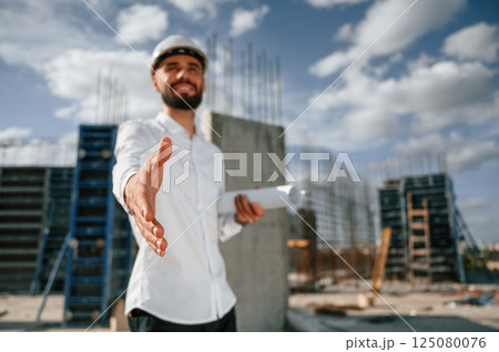 Making a deal. Extending the hand. Man in uniform is working on the construction site Making a deal. Extending the hand. Man in uniform is working on the construction site 125080076