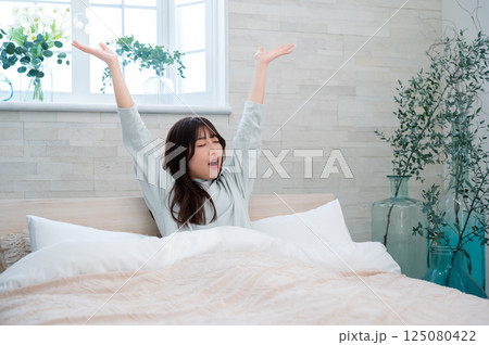 ベッドであくびをする若い女性 ベッドであくびをする若い女性 125080422