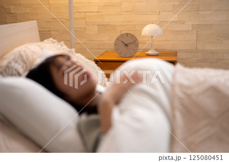 ベッドで眠る若い女性 125080451