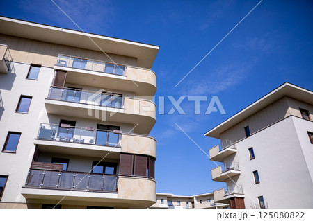 A collection of modern residential buildings set against a clear blue sky, showcasing innovation 125080822