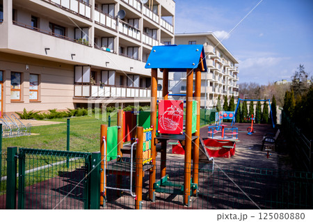 A Vibrant Playground Featuring Modern Equipment is Conveniently Located near a Residential Building 125080880