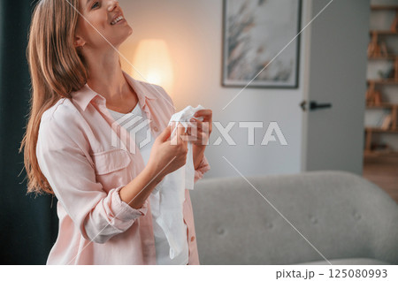 Cute little shirt. Beautiful pregnant woman is indoors at home 125080993