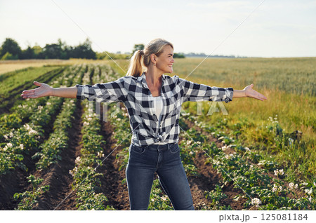 Standing and posing. Woman is on the agricultural field at daytime Standing and posing. Woman is on the agricultural field at daytime 125081184