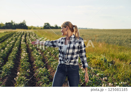 Standing and posing. Woman is on the agricultural field at daytime 125081185