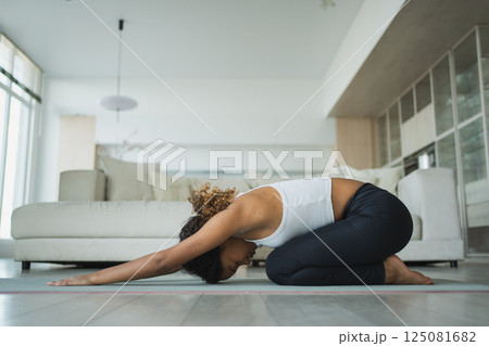 Yoga fitness workout training. Healthy African girl practicing yoga at home. Woman training Pilates doing sports exercise on yoga mat indoor. Girl have training workout for weight loss. Sport fitness 125081682