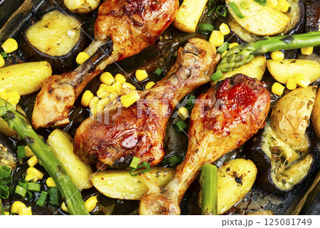 Baked chicken legs with vegetables. 125081749
