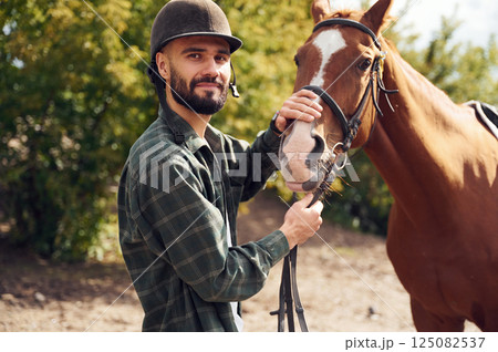 Young man with a horse is outdoors Young man with a horse is outdoors 125082537