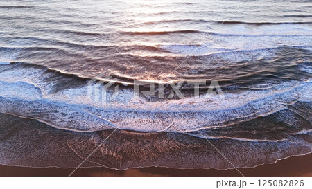 Layered Ocean Waves Rolling Onto Shore at Sunset Layered Ocean Waves Rolling Onto Shore at Sunset 125082826