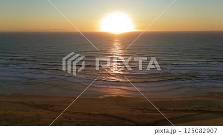 Drone View of Sunset Over Ocean Waves and Beach 125082907