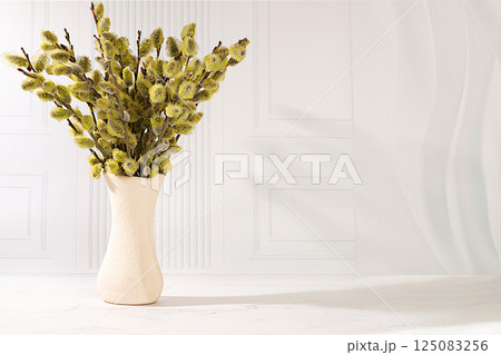 Delicate willow branches in vase on elegant background, abstract spring flower arrangement. Easter card and still life, minimalist holiday concept, religious banner, home interior, selective focus. 125083256