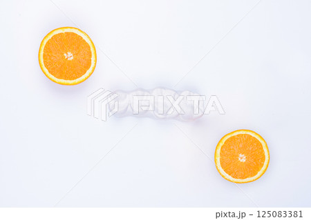 Enlarged anatomical plaster model of four lateral teeth with two halves of an orange on the sides. 125083381