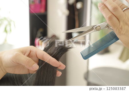 ヘアカットをする美容師の手元 125083387