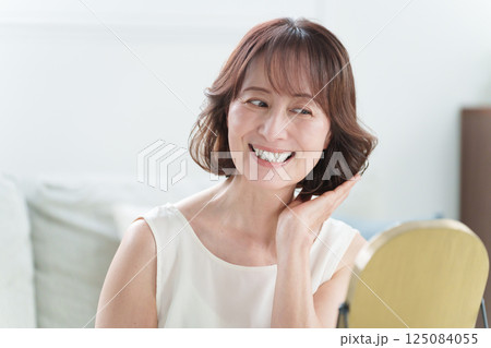 ヘアケアをするシニア女性(髪の毛・美容) ヘアケアをするシニア女性(髪の毛・美容) 125084055