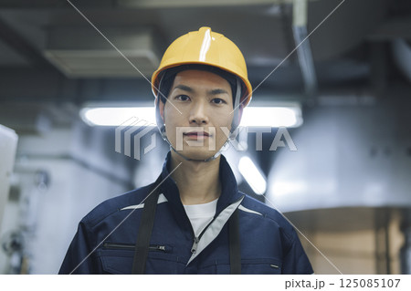 作業服を着たカメラ目線の30代の男性 125085107