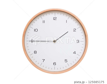 Minimal wall clock with light wood frame and white face displaying 01:45 or 13:45. Perfect for clean, modern concepts about time and scheduling. 125085175