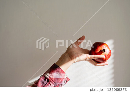 Hand Holds Ripe Pomegranate Fruit Rich in Vitamins and Antioxidants for Vegan Food Menu. Hand Holds Ripe Pomegranate Fruit Rich in Vitamins and Antioxidants for Vegan Food Menu. 125086278