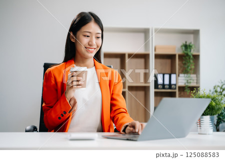 Businesswoman using tablet and laptop for doing math finance on an office desk, tax, 125088583