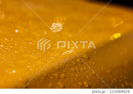 Raindrops shimmering on the vibrant yellow taxi car after a rainy night in the bustling city Raindrops shimmering on the vibrant yellow taxi car after a rainy night in the bustling city 125089029