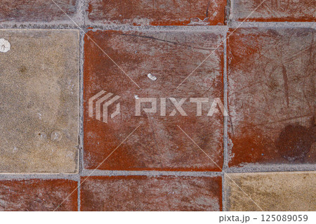 Exploring the rich textures of rustic tiles in a cozy courtyard during a sunny afternoon 125089059
