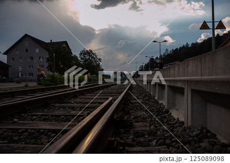 Endless tracks stretch through a tranquil German town under an expansive twilight sky 125089098